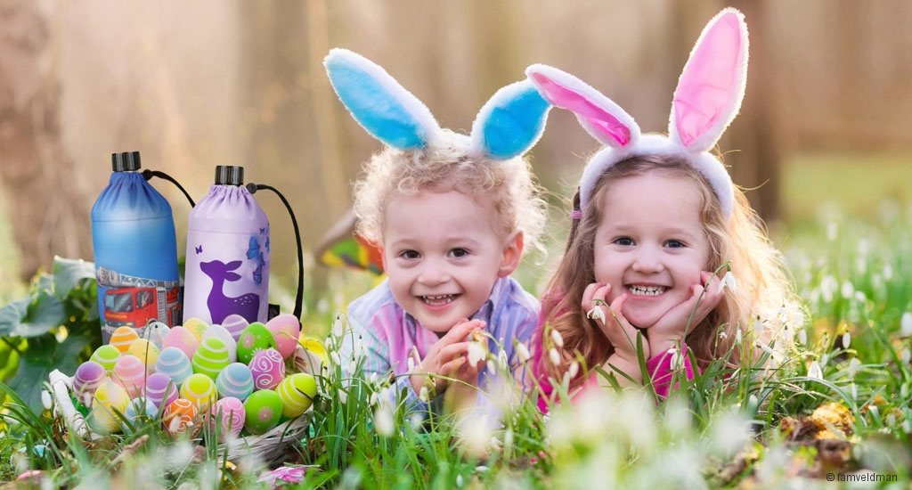 Kids on Easter egg hunt in blooming spring garden